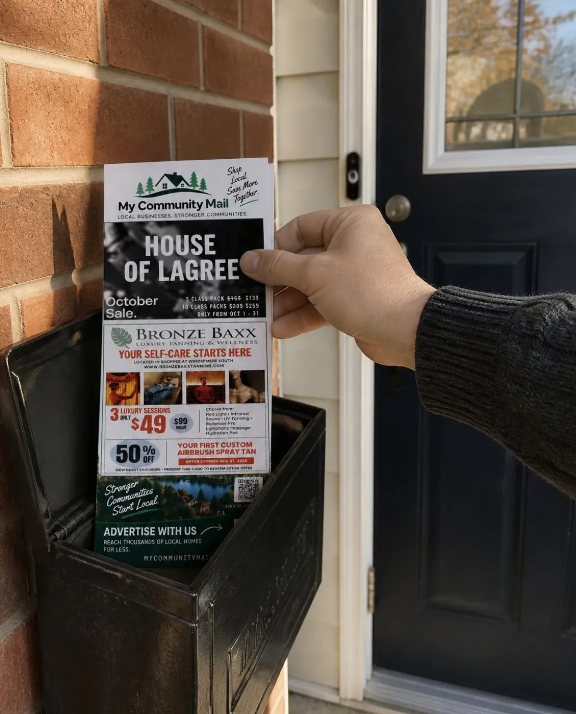 A hand pulling a My Community Mail mailer out of a home mailbox beside the front door.